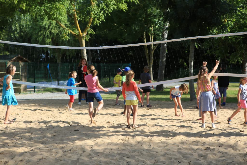 Enfants sur le terrain de beach-volley du camping 5 étoiles à Saint-Hilaire-de-Riez - Le Château